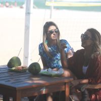 Ticiane Pinheiro bebe água de coco e come sanduíche durante gravação na praia