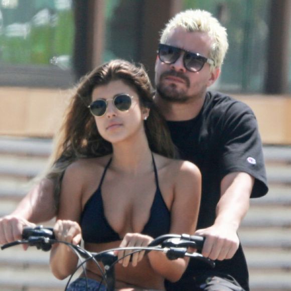 Thiago Martins carrega namorada, Talita Nogueira, em bicicleta durante passeio na orla da praia