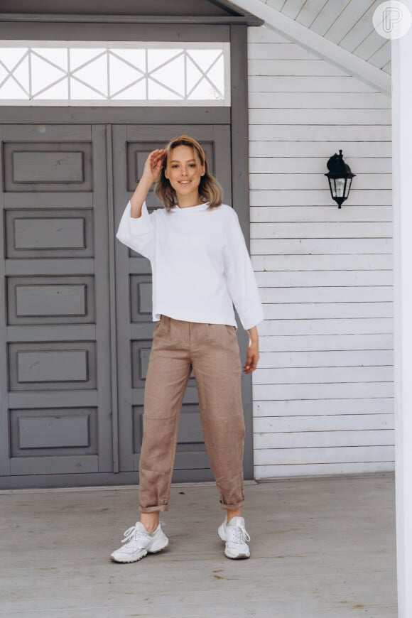 Calça soltinha com dobras na base e a blusa de manga branca: look ideal para época de meia-estação