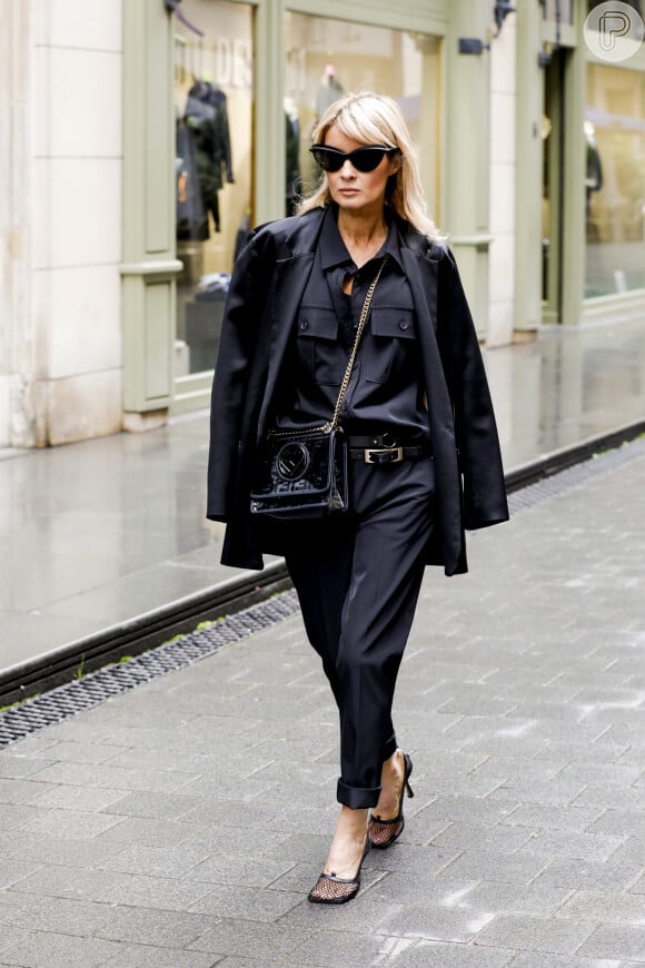 Look all black com camisa de botão e calça pretas e um casaco por cima, que também pode ser uma jaqueta de couro