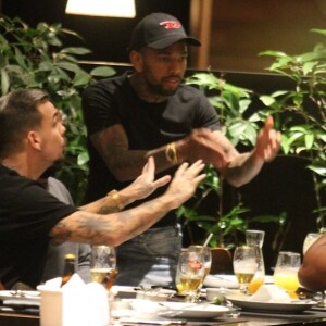 Nego do Borel é fotografado em pé conversando com amigos