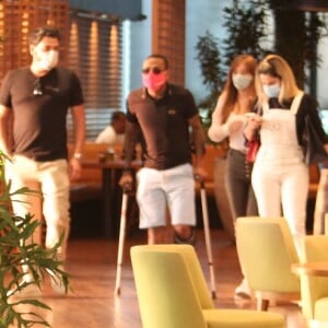 Nego do Borel é clicado caminhando com ajuda de muletas