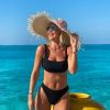 Ana Paula Siebert alia a conjunto moda praia monocromático um maxichapéu de palha nas Maldivas