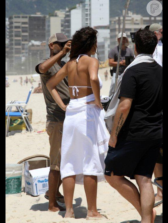Débora Nascimento se cobre com uma toalha depois de gravar comercial