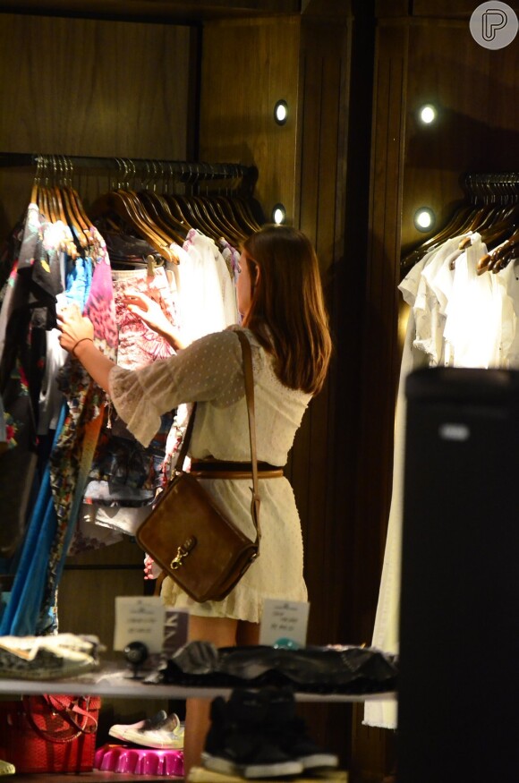 Marina Ruy Barbosa olha roupas de uma loja de shopping carioca