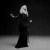 Mariah Carey mostra a boa forma usando um vestido preto e um paletó de mágico
