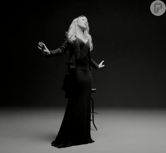 Mariah Carey mostra a boa forma usando um vestido preto e um paletó de mágico
