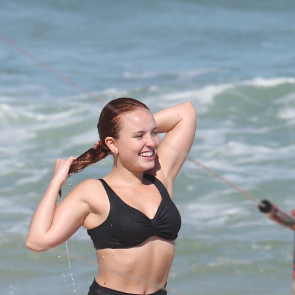 Larissa Manoela arruma cabelo em dia de praia após jogar altinha e frescobol