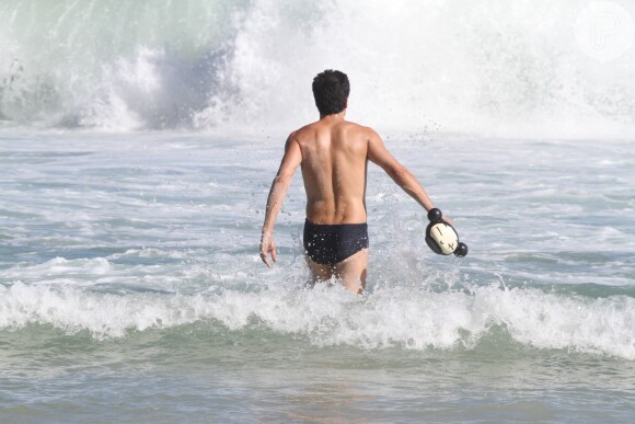 De férias da TV, Mateus Solano tomou banho de mar e carregou o baldinho da filha, Flora, para jogar água no corpo