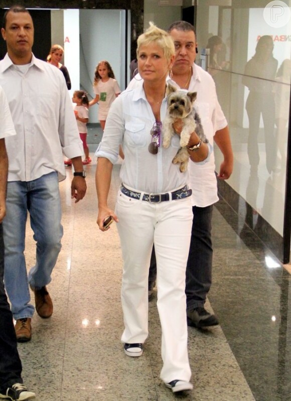 Xuxa e Dudu, o cachorrinho de estimação da cantora, são flagrados durante passeio no shopping