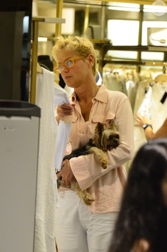 Com o mascote nos braços, Xuxa vê roupa em loja de shopping no Rio