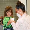 Sabrina Sato ajuda a filha, Zoe, a comer sorvete em aeroporto