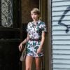 Para um passeio, Taylor Swift usou um macaquinho floral combinado com um scarpin amarelo e um cinto de couro marcando a cintura