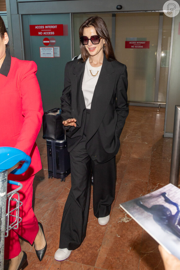 Anne Hathaway, no aeroporto de Cannes, escolheu look mais básico em preto e branco