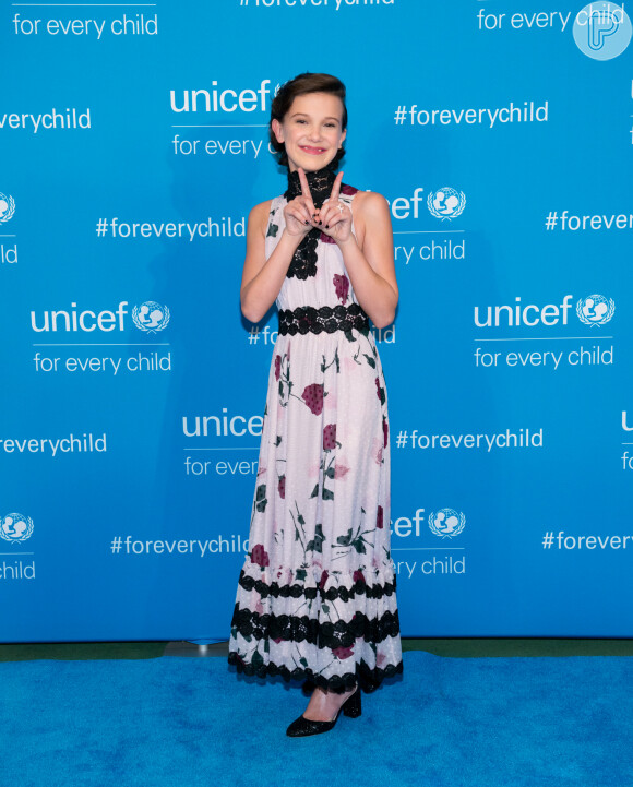 Millie Bobby Brown combinou vestido floral com detalhes pretos a sandália discreta de salto em evento da UNICEF em 2016