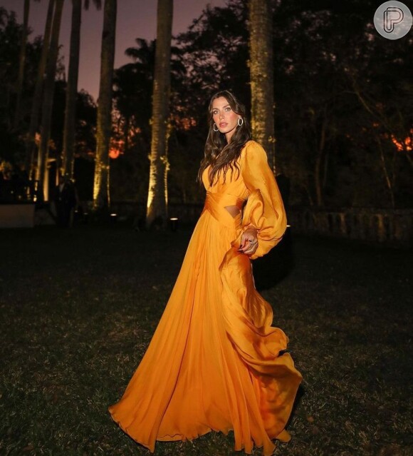 Vestido de festa laranja e com manga longa: Nati Vozza escolheu modelo com recorte na cintura