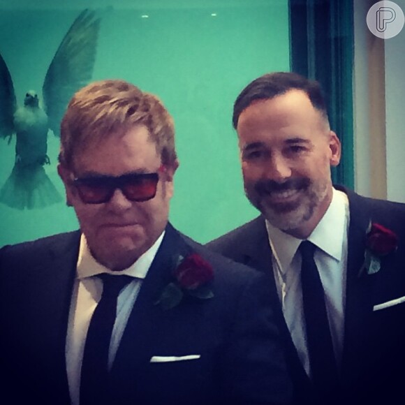 Elton John e David Furnish usaram rosas vermelhas nas lapelas