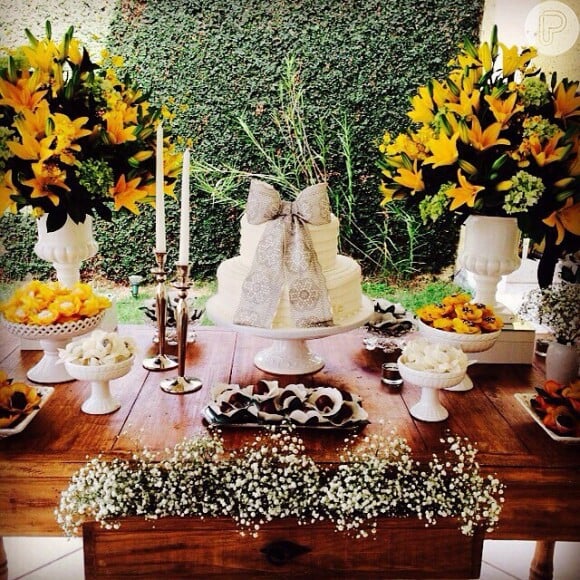 Vanessa Giácomo mostrou o bolo de seu casamento, todo branco, de dois andares e com um grande laço enfeitando, além de parte da decoração da cerimônia, que contou com flores amarelas e brancas