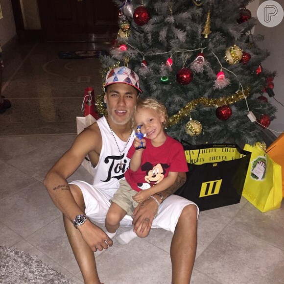 Já com a barba descolorida, Neymar posa diante da árvore de Natal com o filho