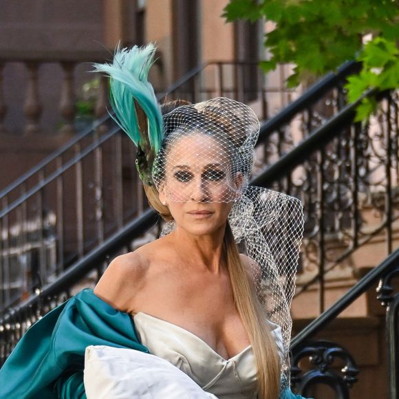 Vestido de noiva de Carrie (Sarah Jessuca Parker) é confeccionado em mikado, tem decote assimétrico com espartilho e uma saia cheia de volume, bufante e com camadas.
