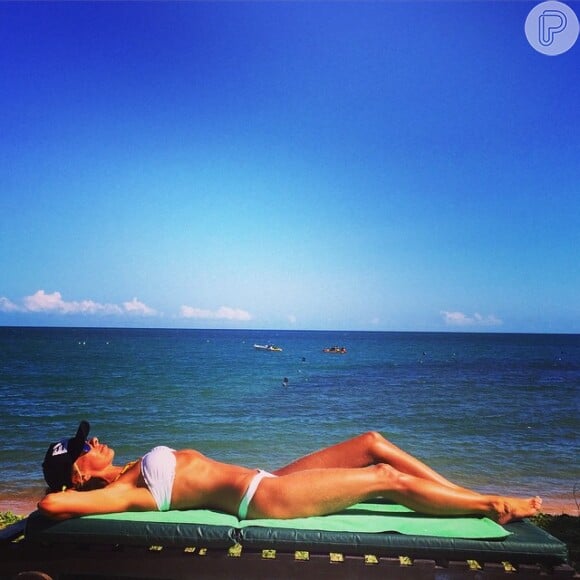 Adriane Galisteu exibe barriga chapada enquanto toma banho de sol na Praia do Forte, na Bahia