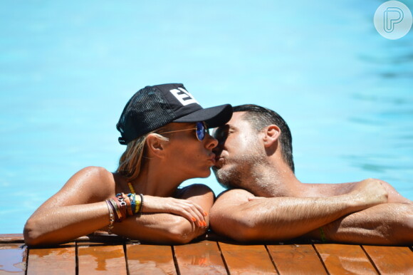 Adriane Galisteu e Alexandre Iódice se beijam na piscina enquanto se refrescam do calor da Bahia