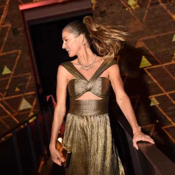 Gisele Bündchen usou vestido elegante em dourado com rabo de cavalo alto