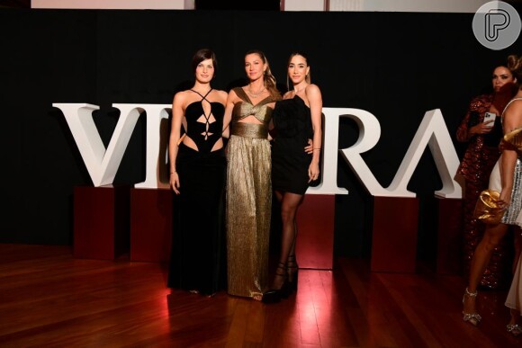 Vestido dourado usado por Gisele Bündchen é do estilista Reinaldo Lourenço: modelo posa com Isabeli Fontana e Romana Novais em evento da Vivara