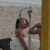 Romulo Neto se refrescou em chuveirinho após surfar no mar do Rio