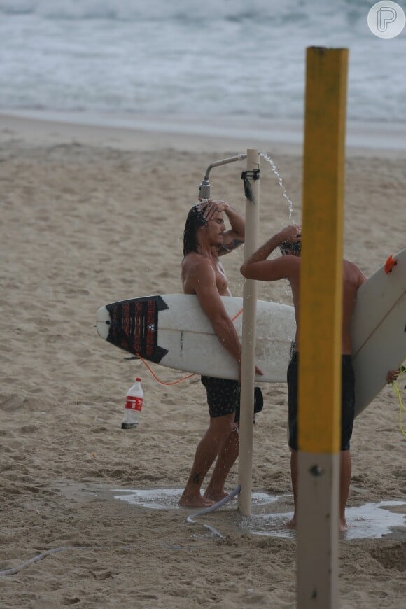 Romulo Neto se refrescou em chuveirinho após surfar no mar do Rio