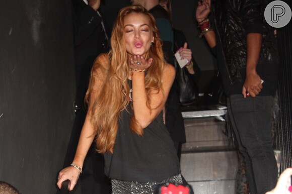 Lindsay Lohan manda beijo para fotógrafos no coquetel da grife John John