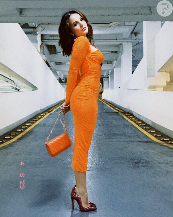 Larissa Manoela usa look laranja justinho em foto tirada em estacionamento em abril de 2023