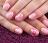 Esmalte rosa delicado faz uma combinação perfeita com nail art floral