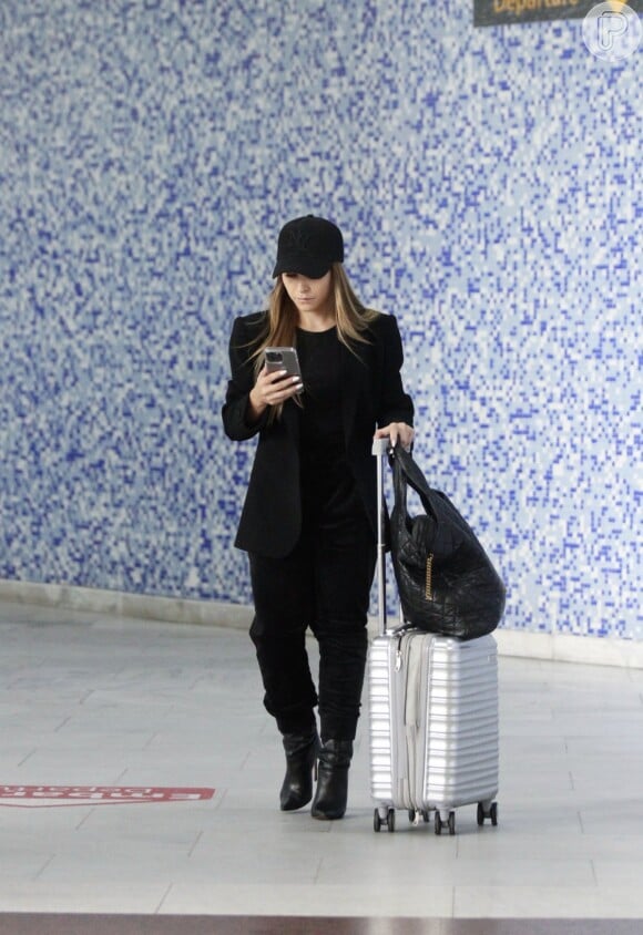 Carla Diaz checou o celular após desembarcar em aeroporto