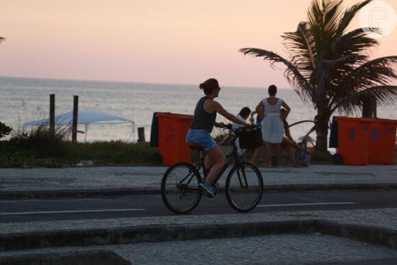 Adriana Esteves anda de bicicleta na orla da praia da Barra da Tijuca, no Rio
