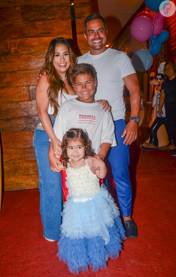 Simone Mendes e Kaká Diniz posam com os dois filhos, Zaya e Henry, na porta do buffet onde a menina comemorou 3 anos