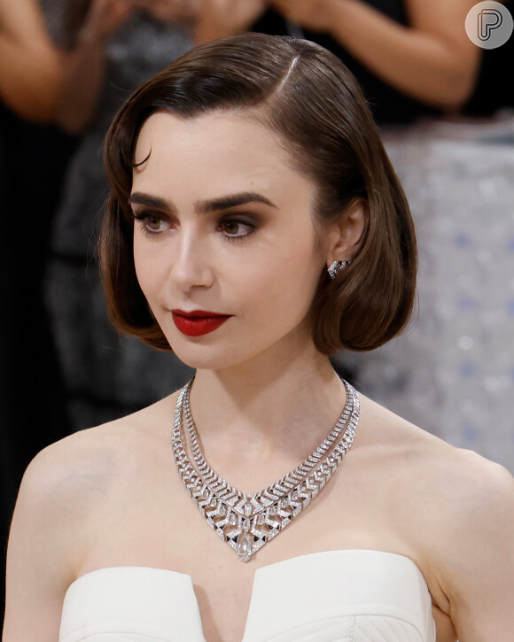 O batom vermelho mais fechado pode transmitir mais elegância, como nessa maquiagem de Lily Collins