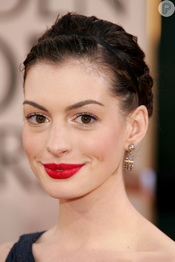 Anne Hathaway escolheu uma maquiagem delicada nos olhos para nesse visual com batom vermelho