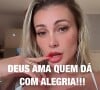 Andressa Urach sensualiza de calcinha e sutiã e exibe a língua bifurcada. A frase 'Deus ama quem dá com alegria!' ilustra o vídeo