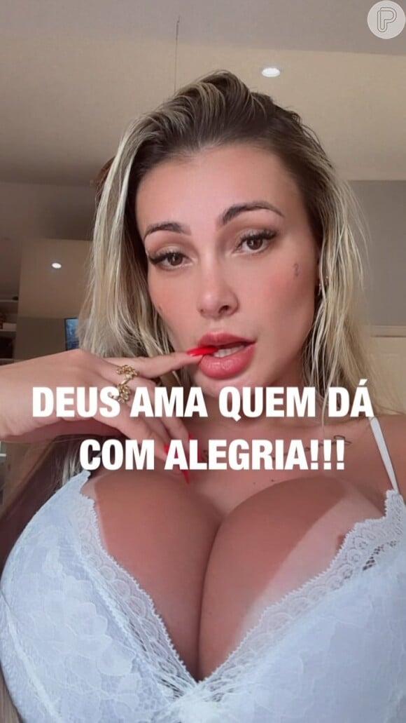 Andressa Urach sensualiza de calcinha e sutiã e exibe a língua bifurcada. A frase 'Deus ama quem dá com alegria!' ilustra o vídeo