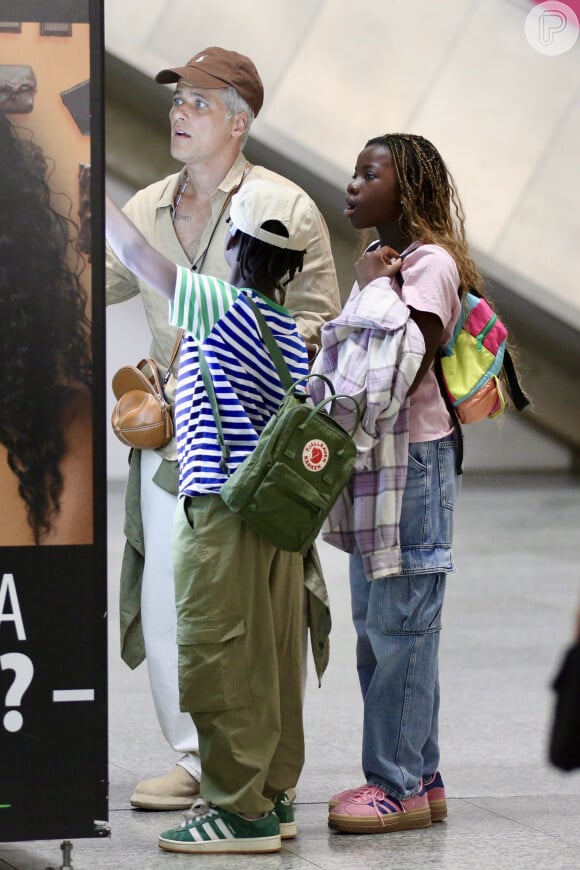 Filhos param pra olhar vitrine com Bruno Gagliasso em Aeroporto do Rio