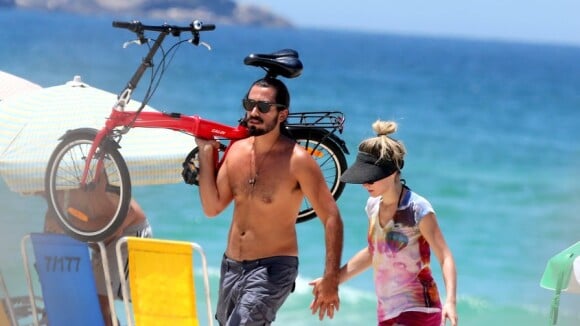 Bianca Bin pedala e encontra o marido, Pedro Brandão, em praia no Rio