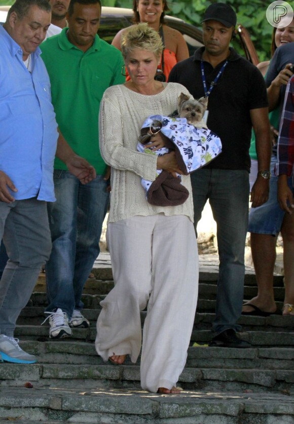 Xuxa chegou à locação segurando o seu inseparável cachorrinho Dudu enrolado num edredom