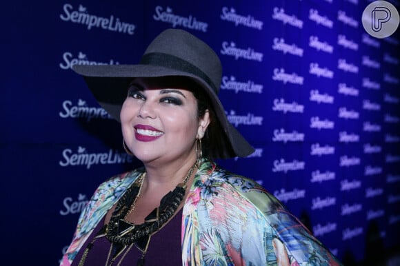 A atriz Fabiana Karla usa um look colorido e um chapéu preto, no Lollapalooza