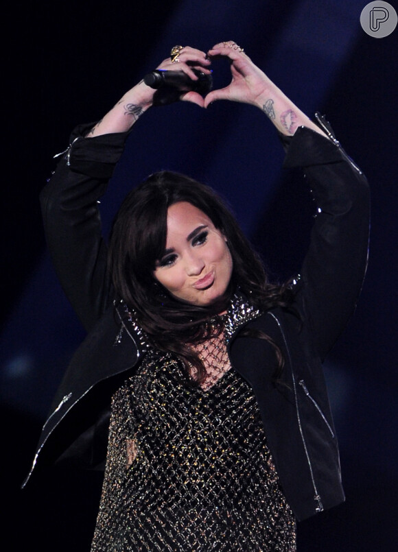 Demi Lovato cobre tatuagem do beijo em seu braço com uma rosa. A cantora mostrou o resultado em seu Instagram, nesta terça-feira, 7 de abril de 2015