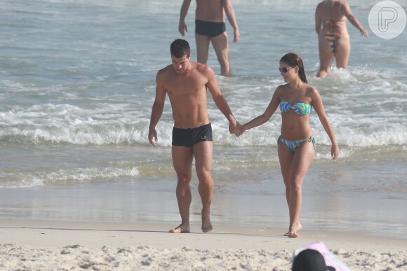 Em passeio na praia da Zona Sul do Rio, Thiago Martins e Paloma Bernardi exibem boa forma