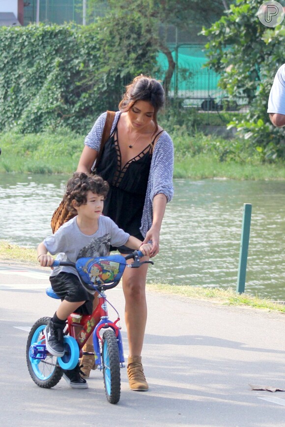 Daniele Suzuki ajuda o filho, Kauai, de 3 anos, a andar de bicicleta, na Lagoa, no Rio de Janeiro