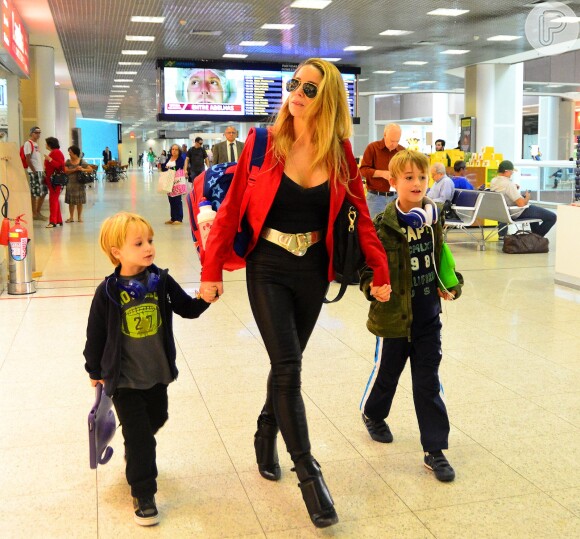 Danielle Winits circula estilosa pelo aeroporto do Rio, de mãos dadas com os filhos, Noah, de 7 anos, e Guy, de 3