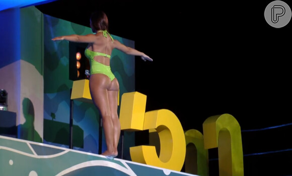 Com um maiô verde, Carol Nakmura mostrou a boa forma ao saltar da plataforma de cinco metros no 'Saltibum'