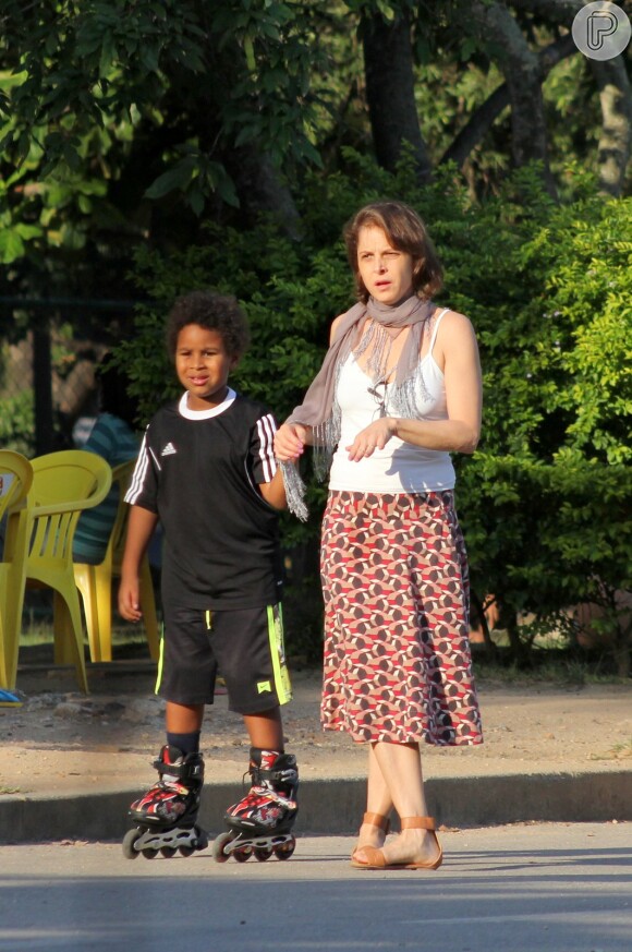 Drica Moraes dá aos mãos ao filho enquanto o ensina a andar de patins